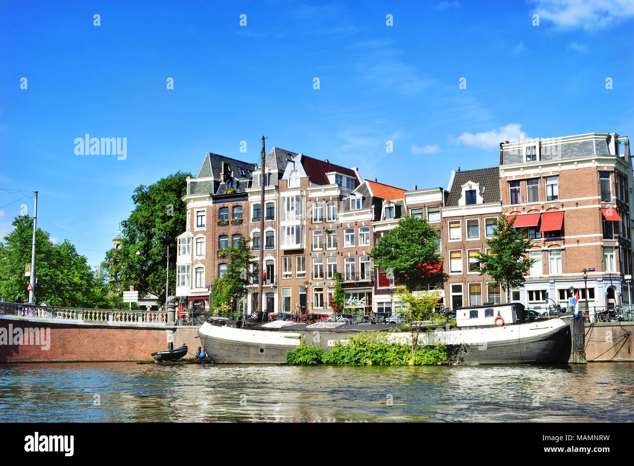 Canal ou gracht à Amsterdam City. Scène de rivière Amstel avec des bateaux et des maisons anciennes. Banque D'Images