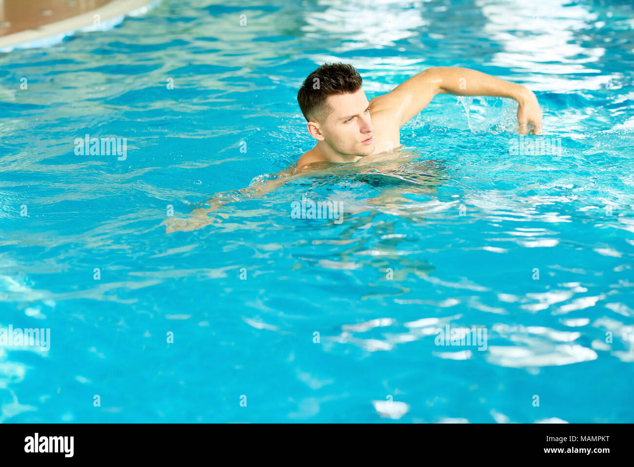 Handsome Man swimming in Pool Banque D'Images