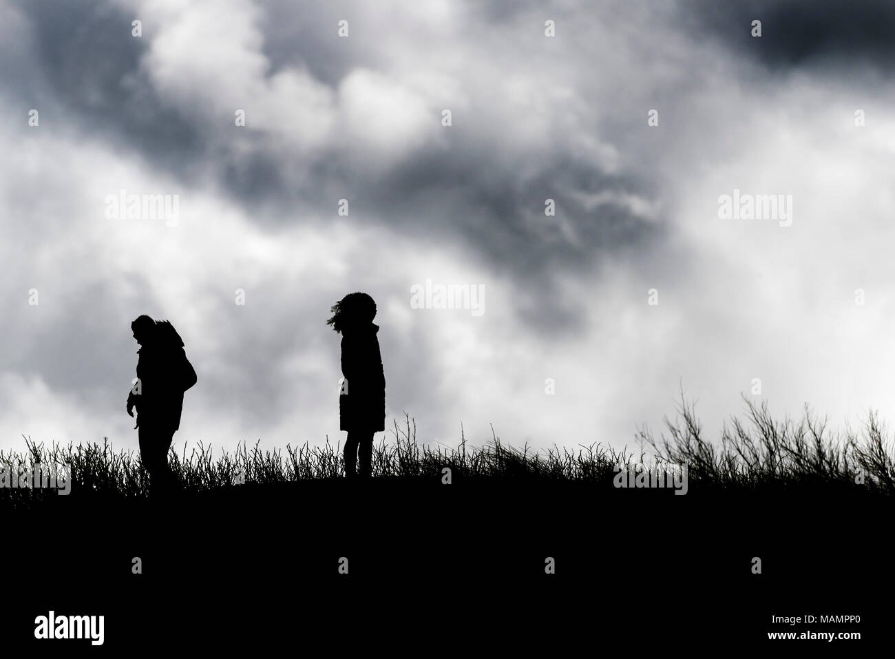 La silhouette de personnes debout contre un ciel nuageux. Banque D'Images