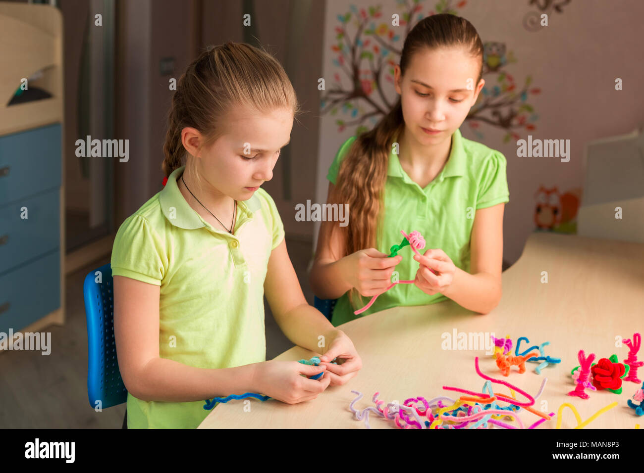 Cute little girls création de jouets avec des bâtons de chenille à la table. La créativité et l'idée à la main. Banque D'Images