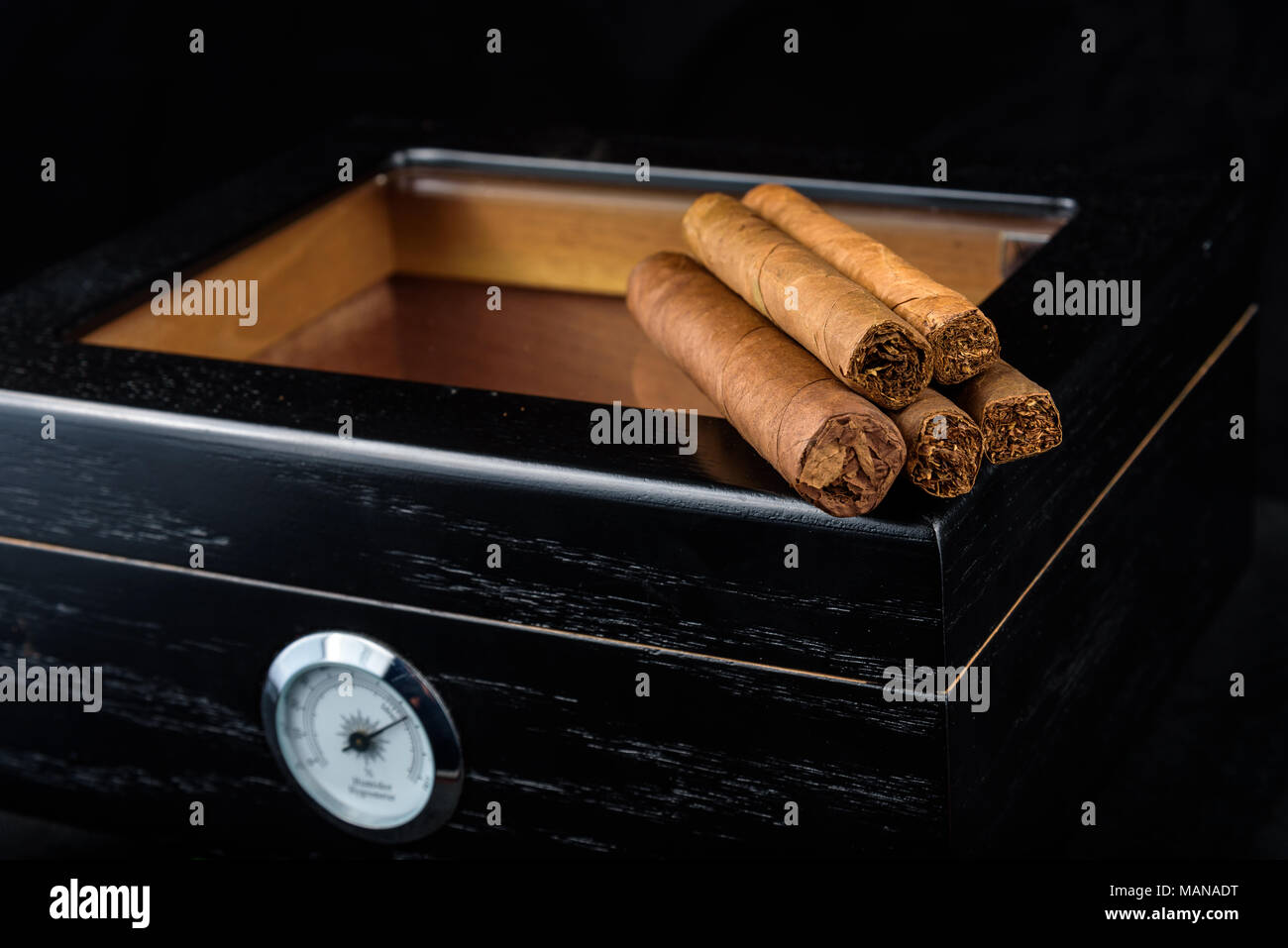 Un tas de produits frais au-dessus d'une cave à cigares noire. Fond noir Banque D'Images