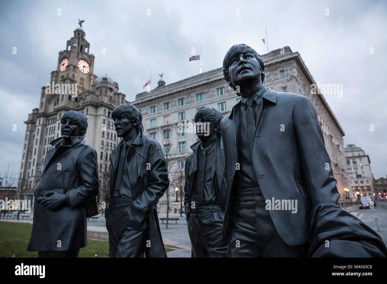 LIVERPOOL, Royaume-Uni - 18 mars 2018 : Close up of the Beatles de statues dans le pier head à Liverpool avec le Royal Liver Building en arrière-plan. Banque D'Images