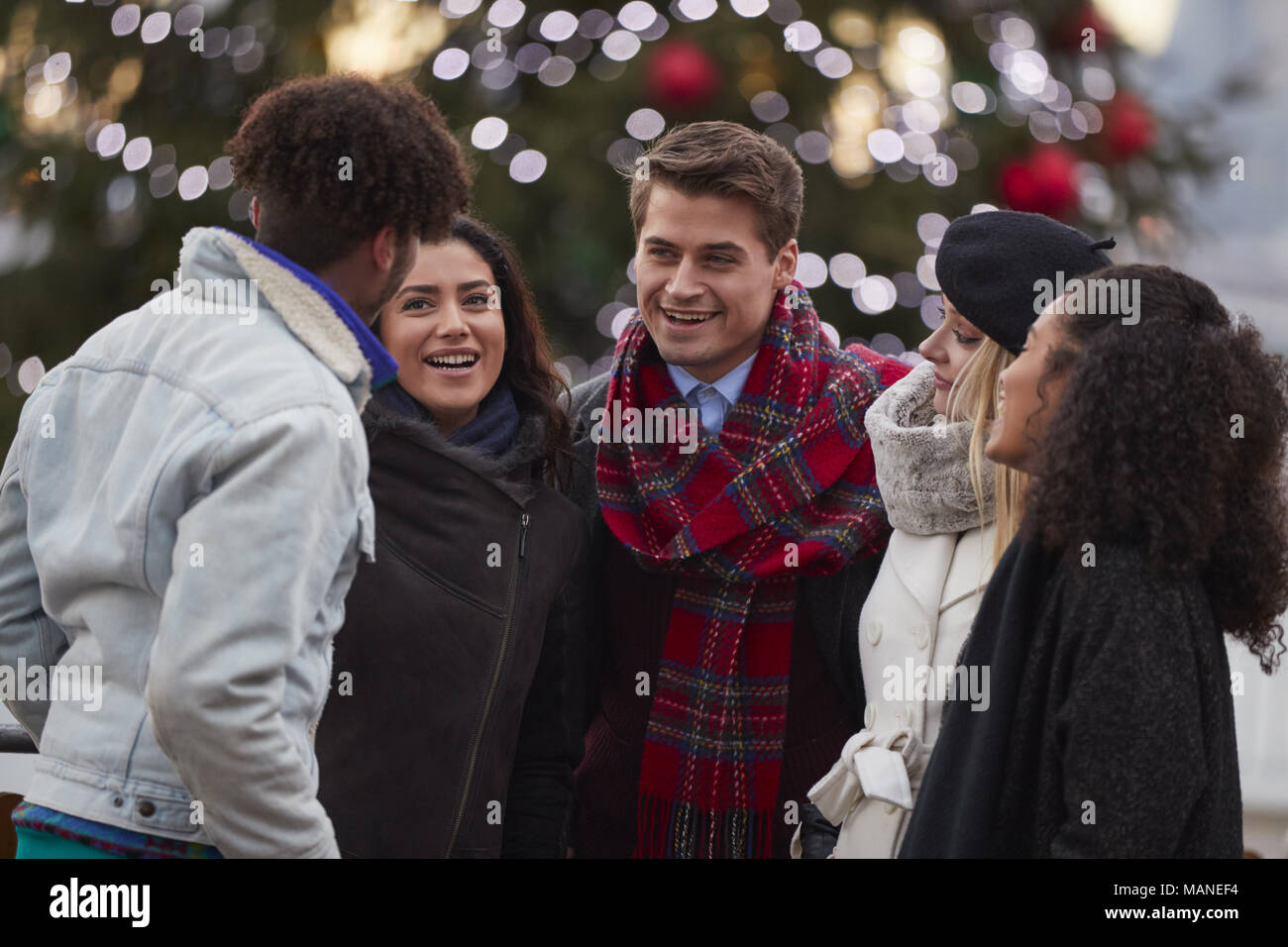 Les jeunes amis de marcher debout By Christmas Tree Banque D'Images