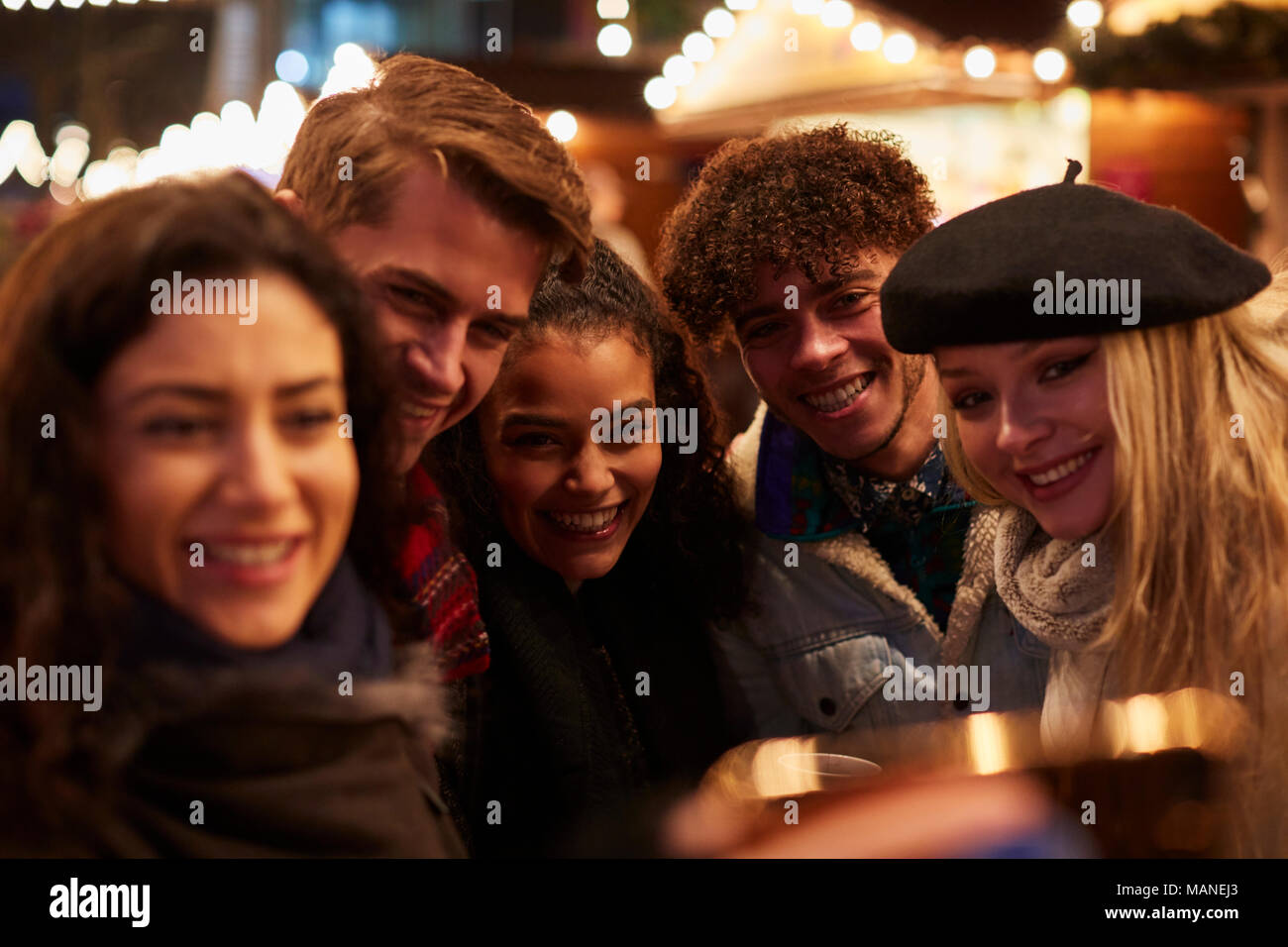 Jeunes amis qui pose pour le marché de Noël à Selfies Banque D'Images