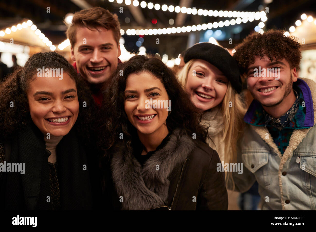 Jeunes amis qui pose pour le marché de Noël à Selfies Banque D'Images