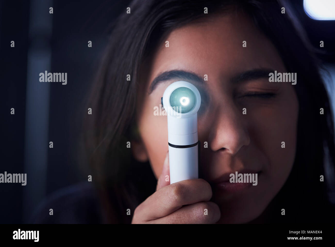 Femme médecin à l'aide d'un otoscope pour examen Banque D'Images