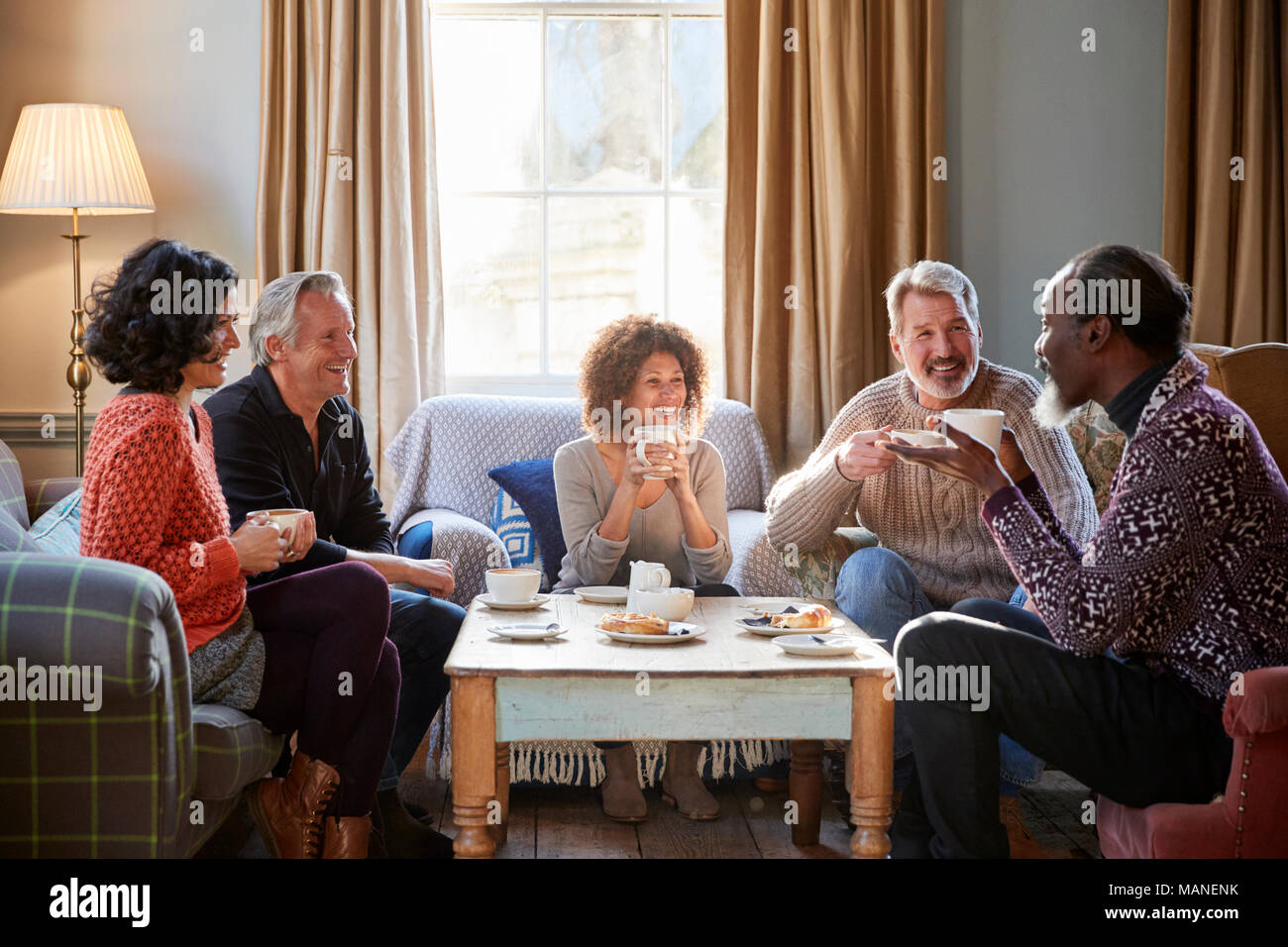 Groupe d'amis d'âge moyen autour de Réunion Table Dans Coffee Shop Banque D'Images