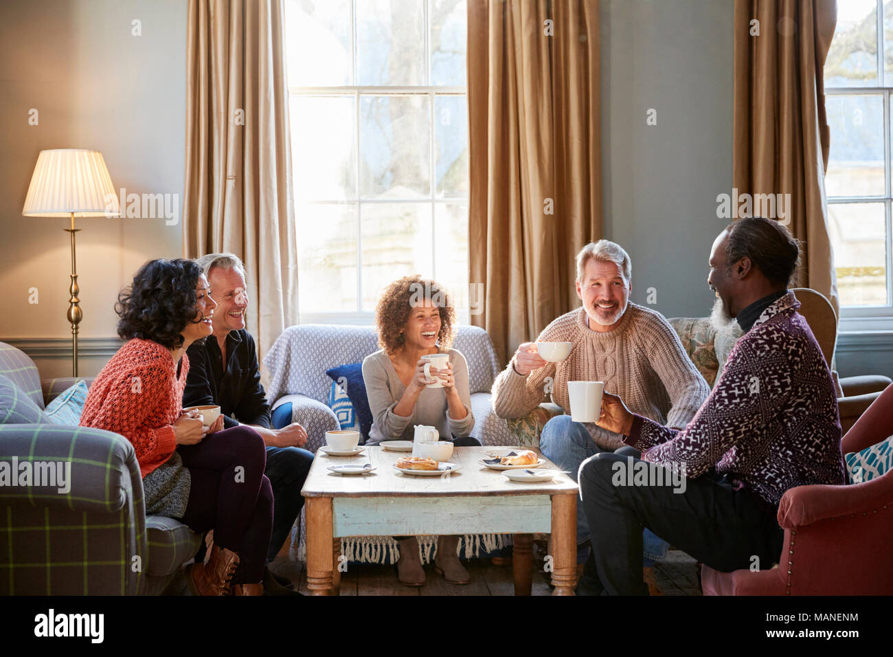 Groupe d'amis d'âge moyen autour de Réunion Table Dans Coffee Shop Banque D'Images