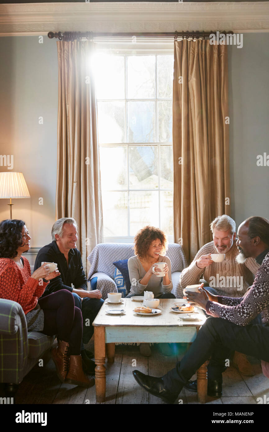 Groupe d'amis d'âge moyen autour de Réunion Table Dans Coffee Shop Banque D'Images