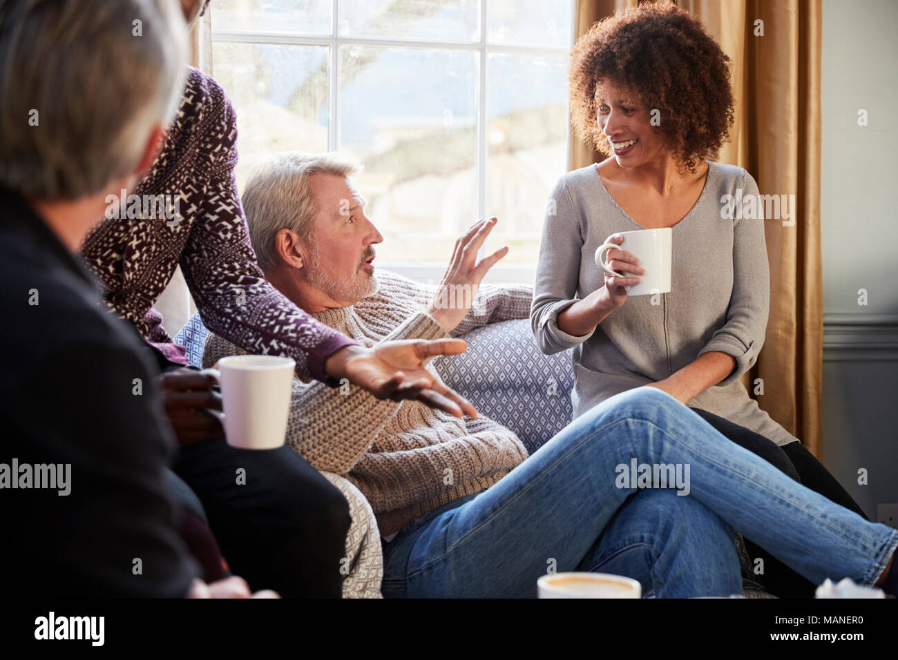 Groupe d'amis d'âge moyen autour de Réunion Table Dans Coffee Shop Banque D'Images
