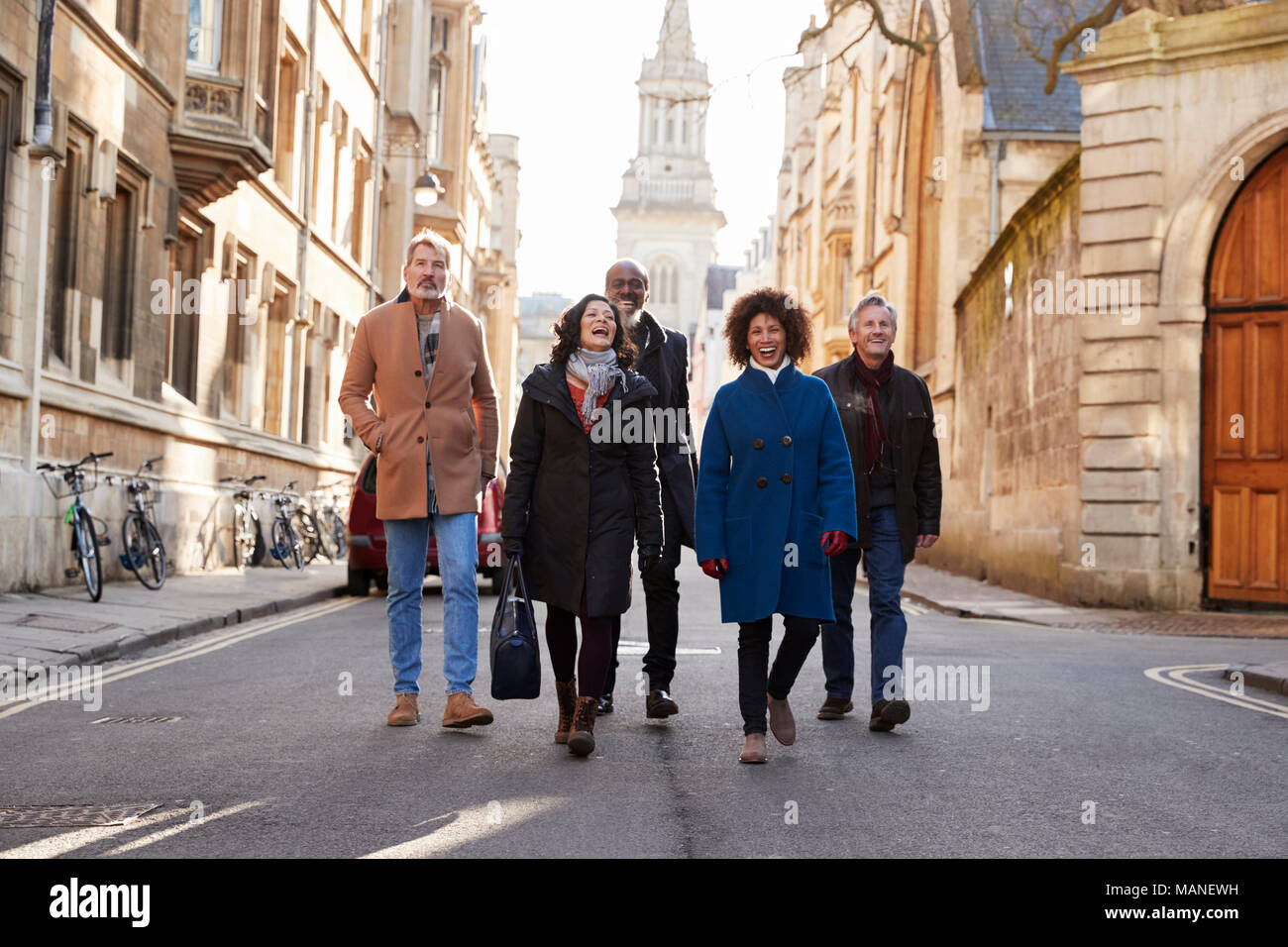 Groupe d'amis à maturité grâce à la marche à l'automne de la ville Ensemble Banque D'Images