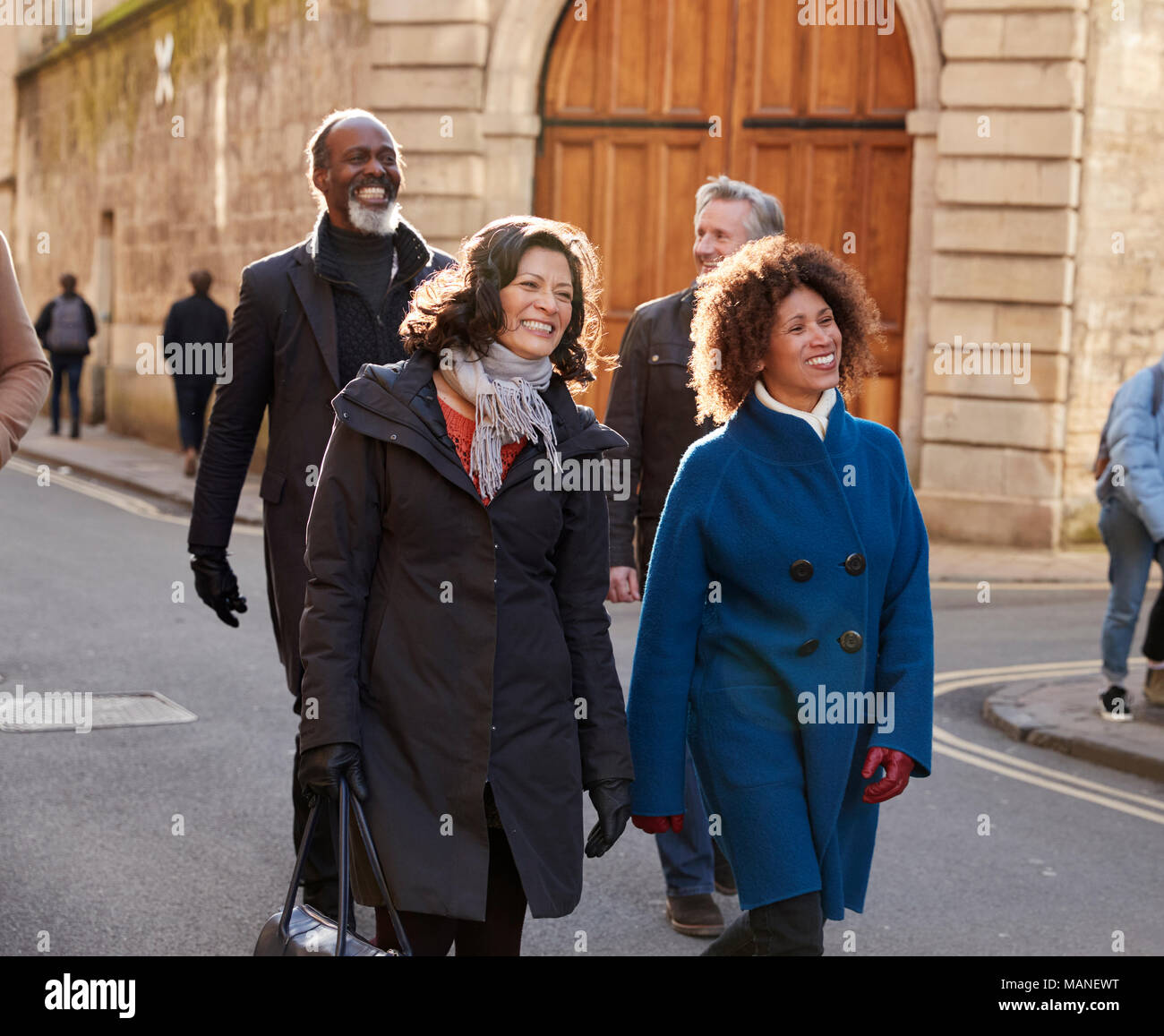 Groupe d'amis à maturité grâce à la marche à l'automne de la ville Ensemble Banque D'Images