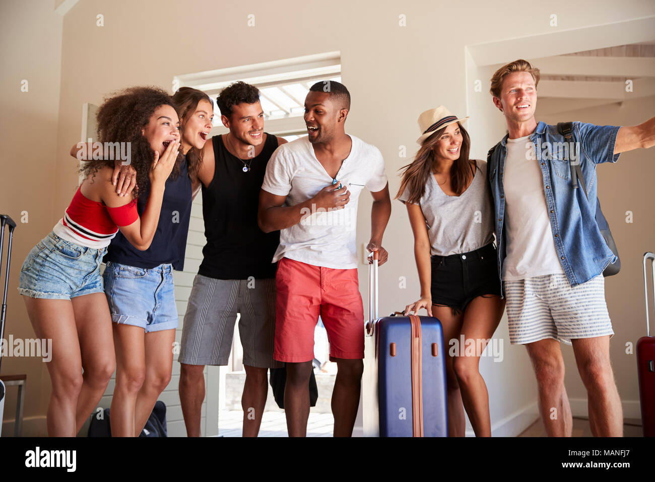 Groupe d'amis arrivant à la location de vacances d'été Banque D'Images