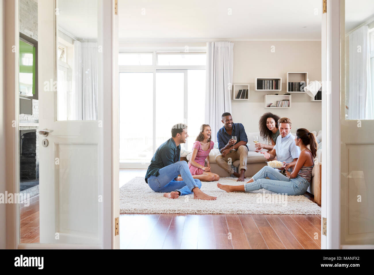 Groupe d'amis à la maison et boire du vin ensemble Banque D'Images
