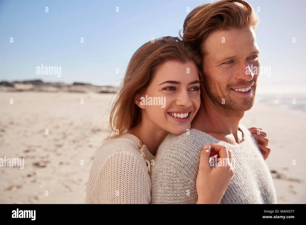 Hiver romantique Couple Embracing On Beach Banque D'Images