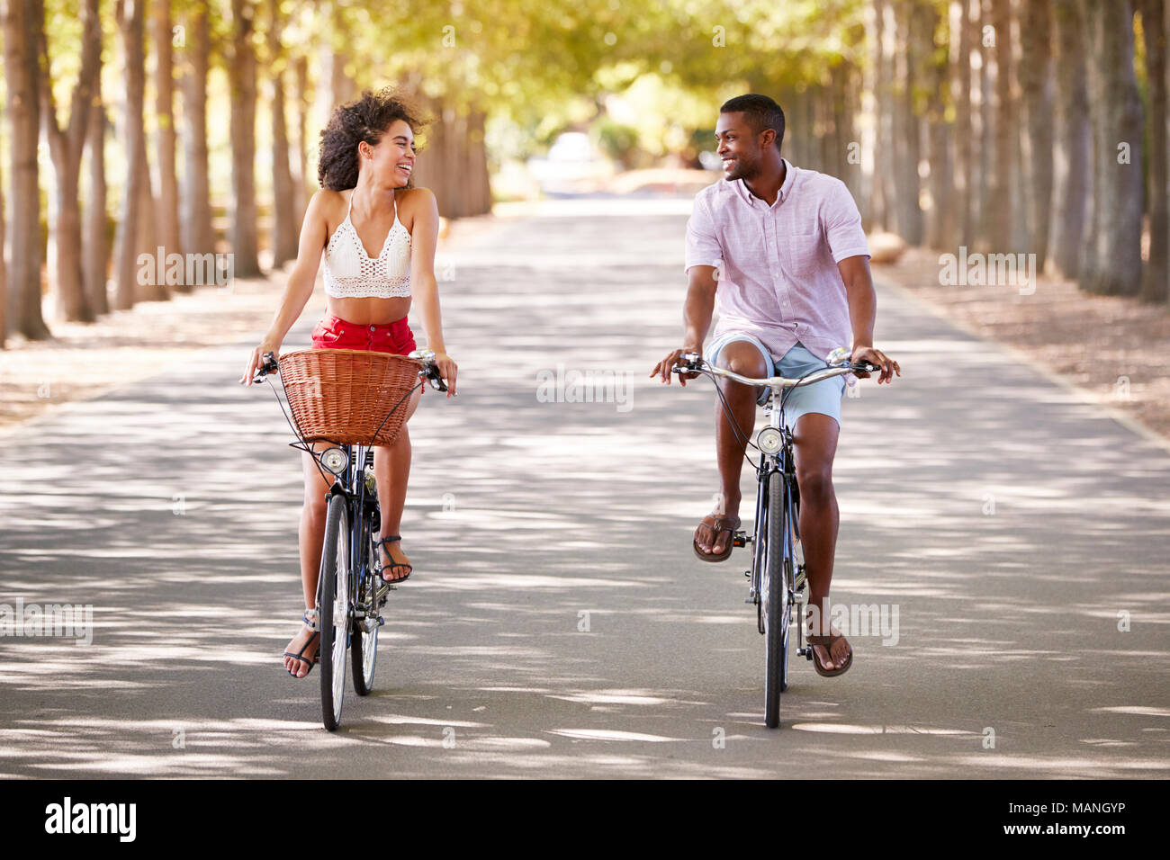Young caucasian couple riding bicycles looking at each other Banque D'Images