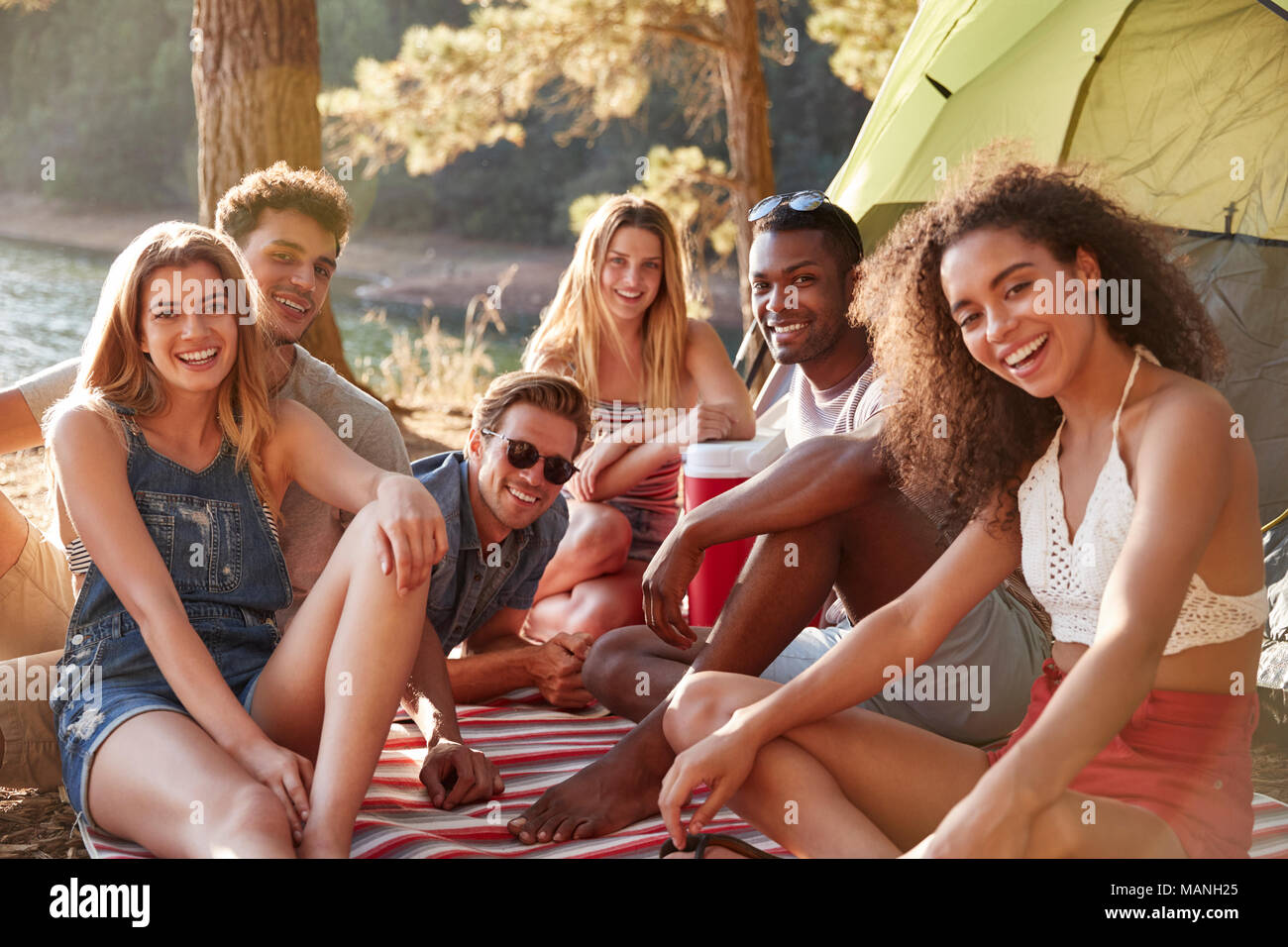 Les amis se détendre sur une couverture par un lac, Close up Banque D'Images