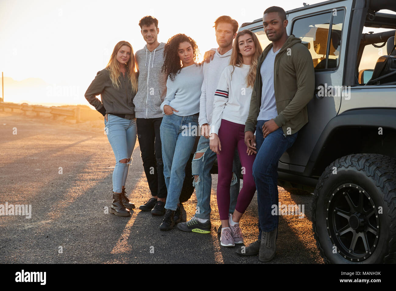 Les amis des jeunes adultes d'un voyage en jeep par leurs commandes Banque D'Images Les amis des jeunes adultes d'un voyage en jeep par leurs commandes Banque D'Images