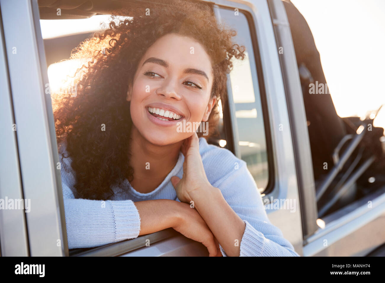 Jeune femme à l'écart hors de la fenêtre ouverte d'une voiture Banque D'Images