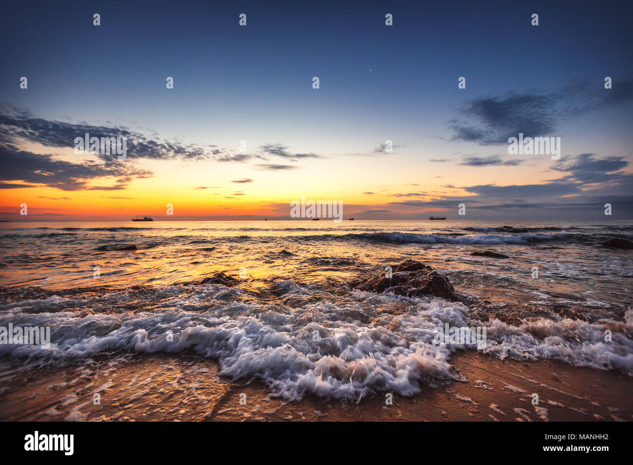 Scenic lever du soleil. Belle lune dans le ciel et de voiliers dans la mer. Banque D'Images