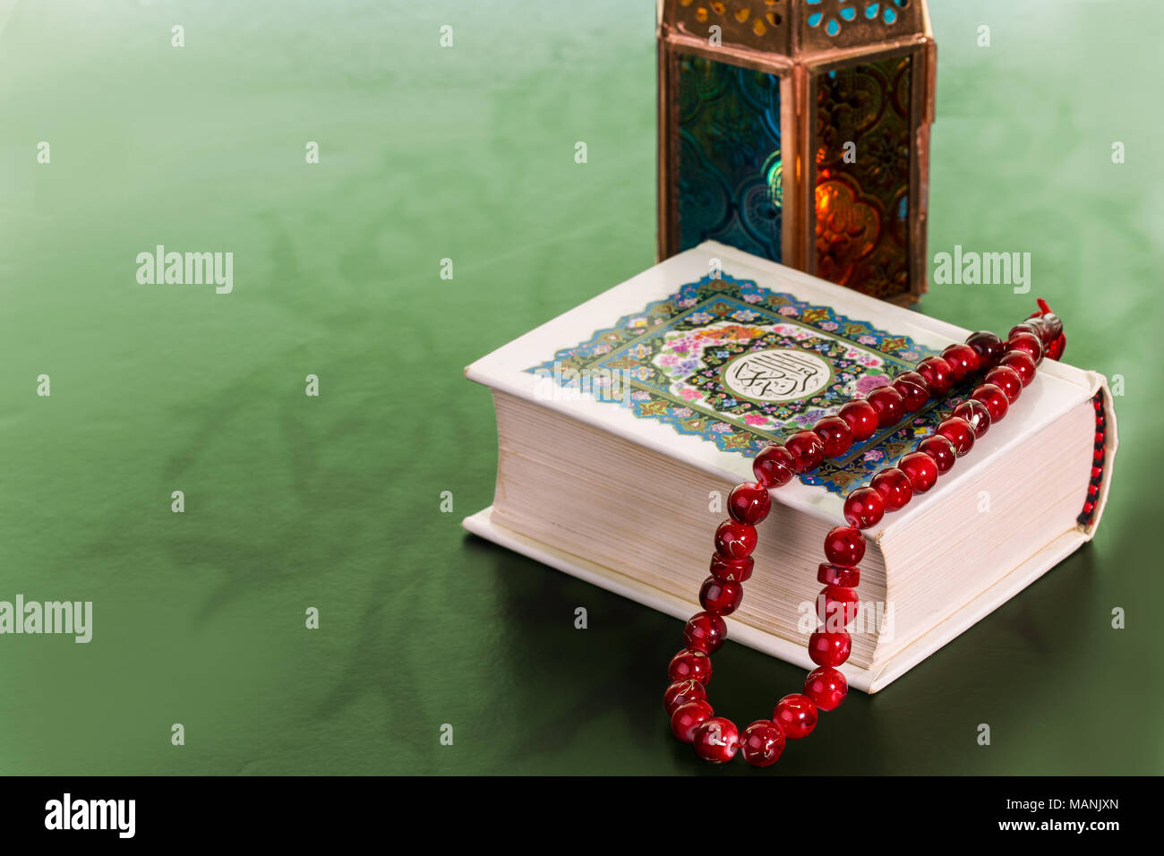 Close Up of livre saint du Coran et du Rosaire et une lanterne sur fond vert, le Ramadan Kareem Concept Banque D'Images