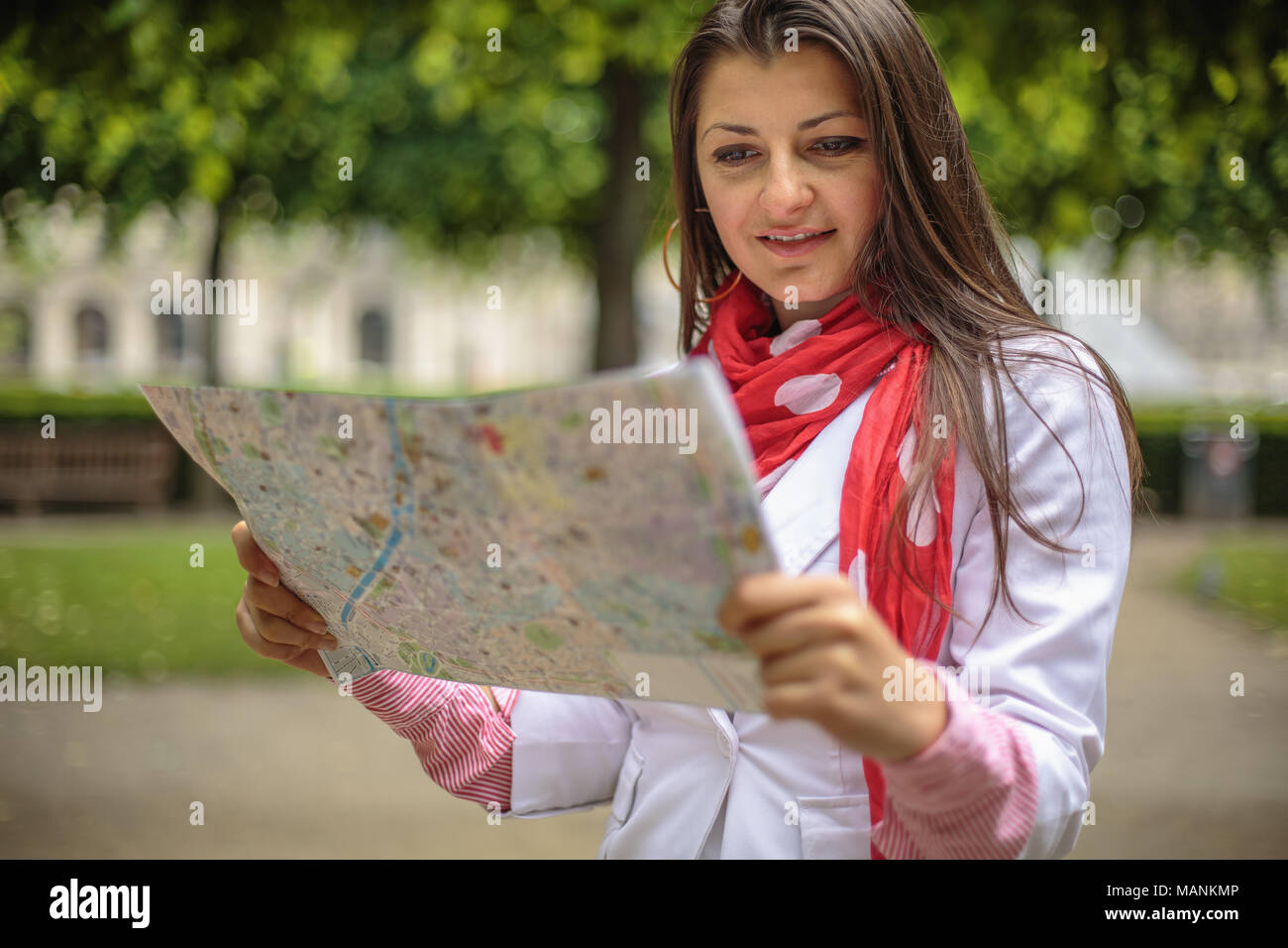Femme à la recherche sur la carte au city park, Paris, France Banque D'Images
