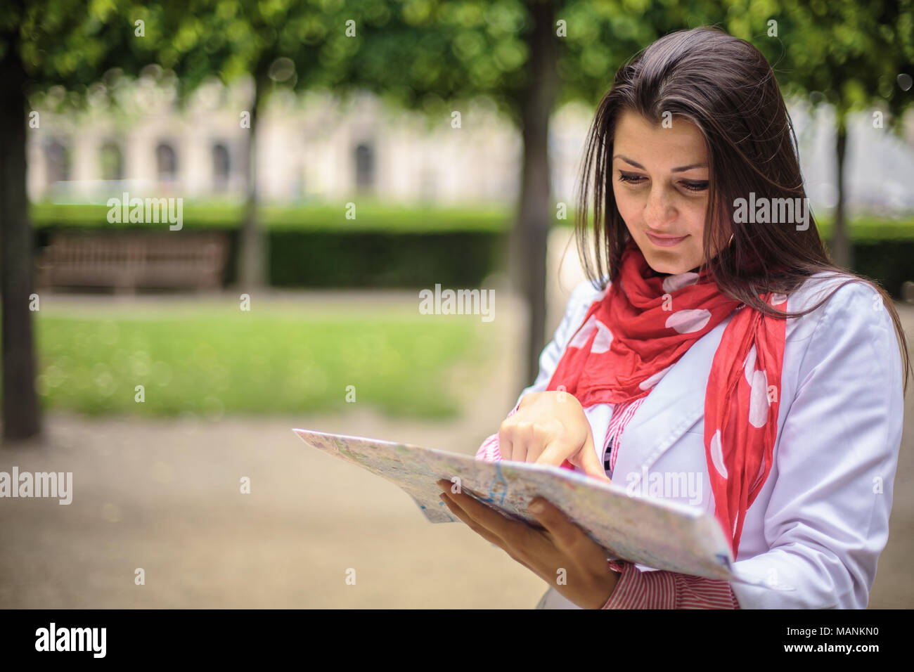 Femme à la recherche sur la carte au city park, Paris, France Banque D'Images