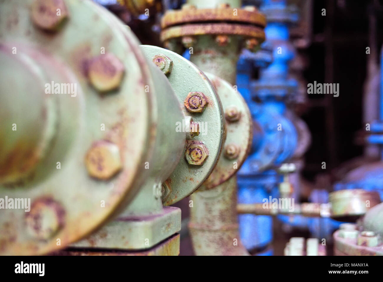 L'industrie et de vieux tuyaux. Rusty valve rotative et tuyaux dans une usine abandonnée. Banque D'Images