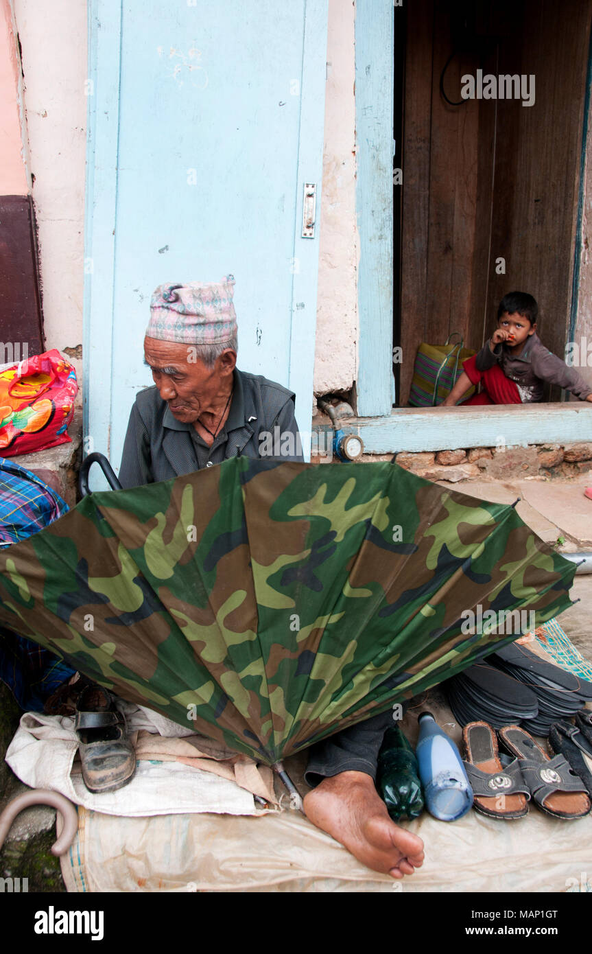 Népal 2014. Khanbari. Parapluie et réparateur de chaussures. Banque D'Images