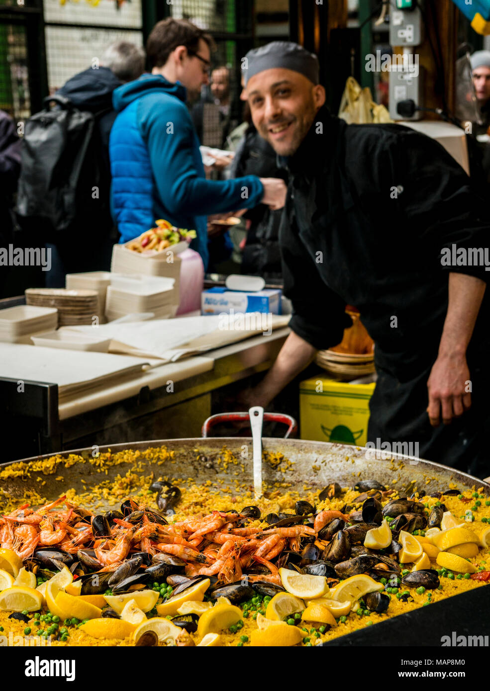 L'homme préparer la paella dans un grand poêlon, Borough Market, Southwark, London, England, UK Banque D'Images