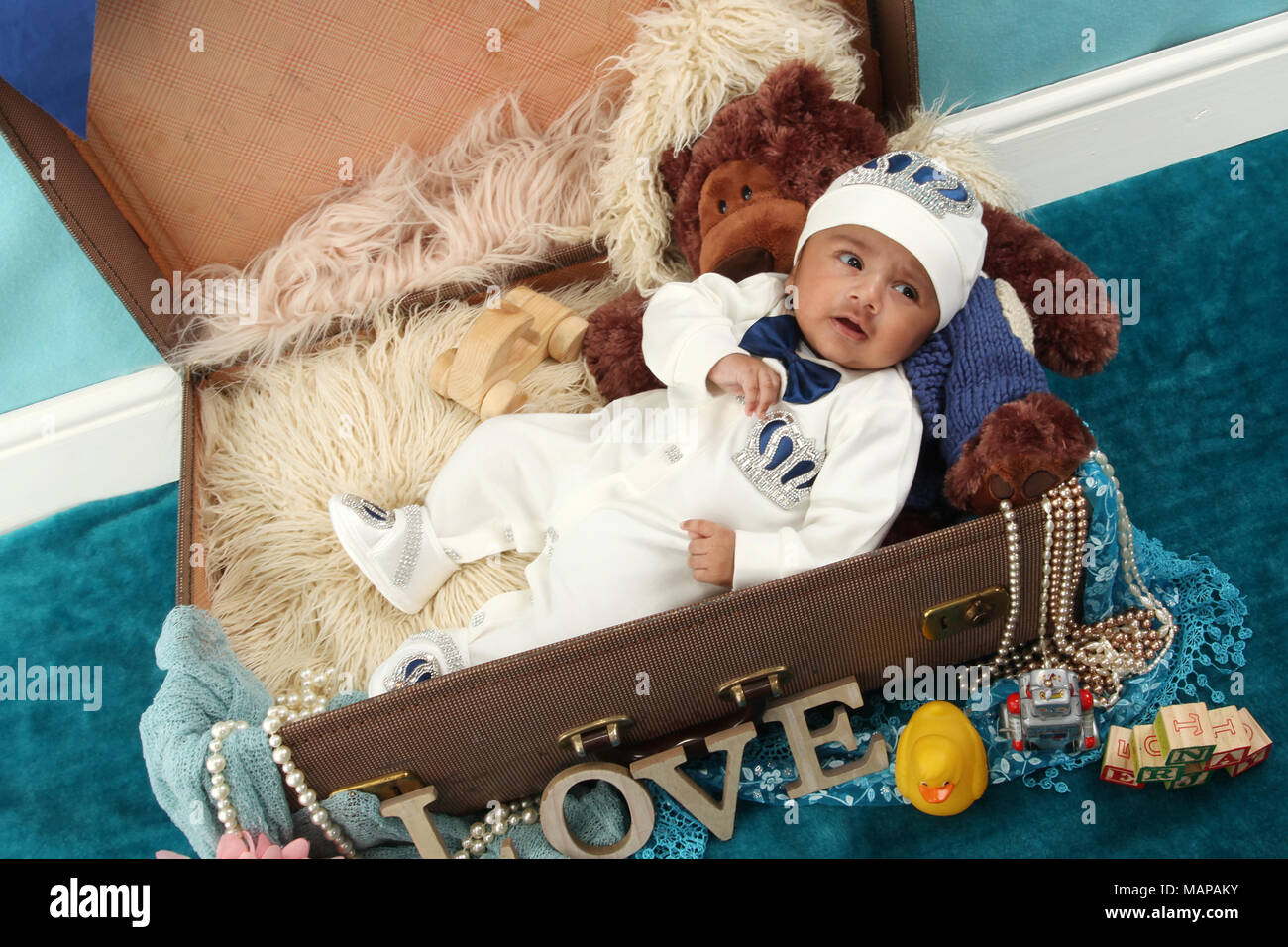 10 semaine vieux garçon bébé ethnique en vintage suitcase Banque D'Images