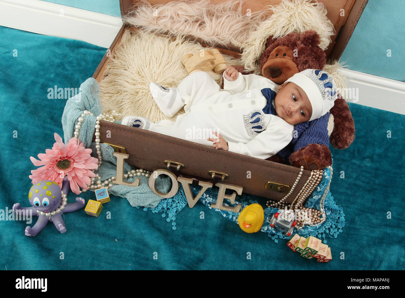 10 semaine vieux garçon bébé ethnique en vintage suitcase Banque D'Images