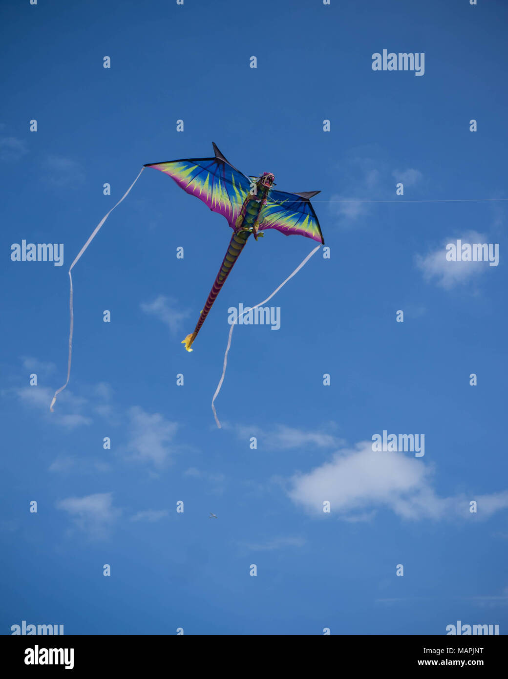 Un cerf-volant dragon contre s ciel bleu avec des nuages blancs Banque D'Images