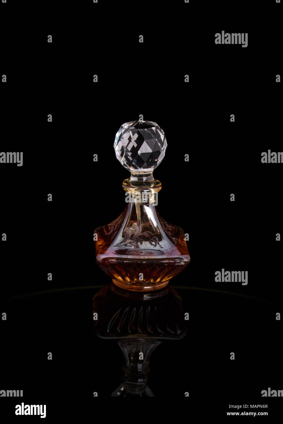 Gros plan de luxe traditionnel arabe Oud Parfum d'huile dans un beau bol en verre de cristal clair fait main et bouteille compte-gouttes en verre isolé sur Black Banque D'Images