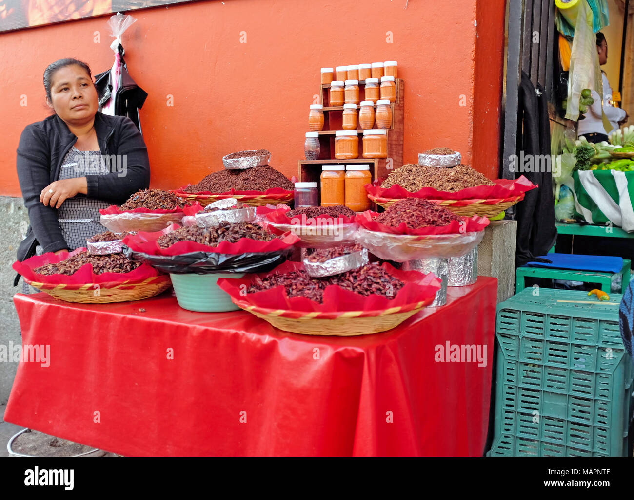 Une femme est assise à son vendeur alimentaire décrochage de fortune à l'extérieur de l'entrée de la principale zone de marché à Oaxaca, au Mexique. Banque D'Images