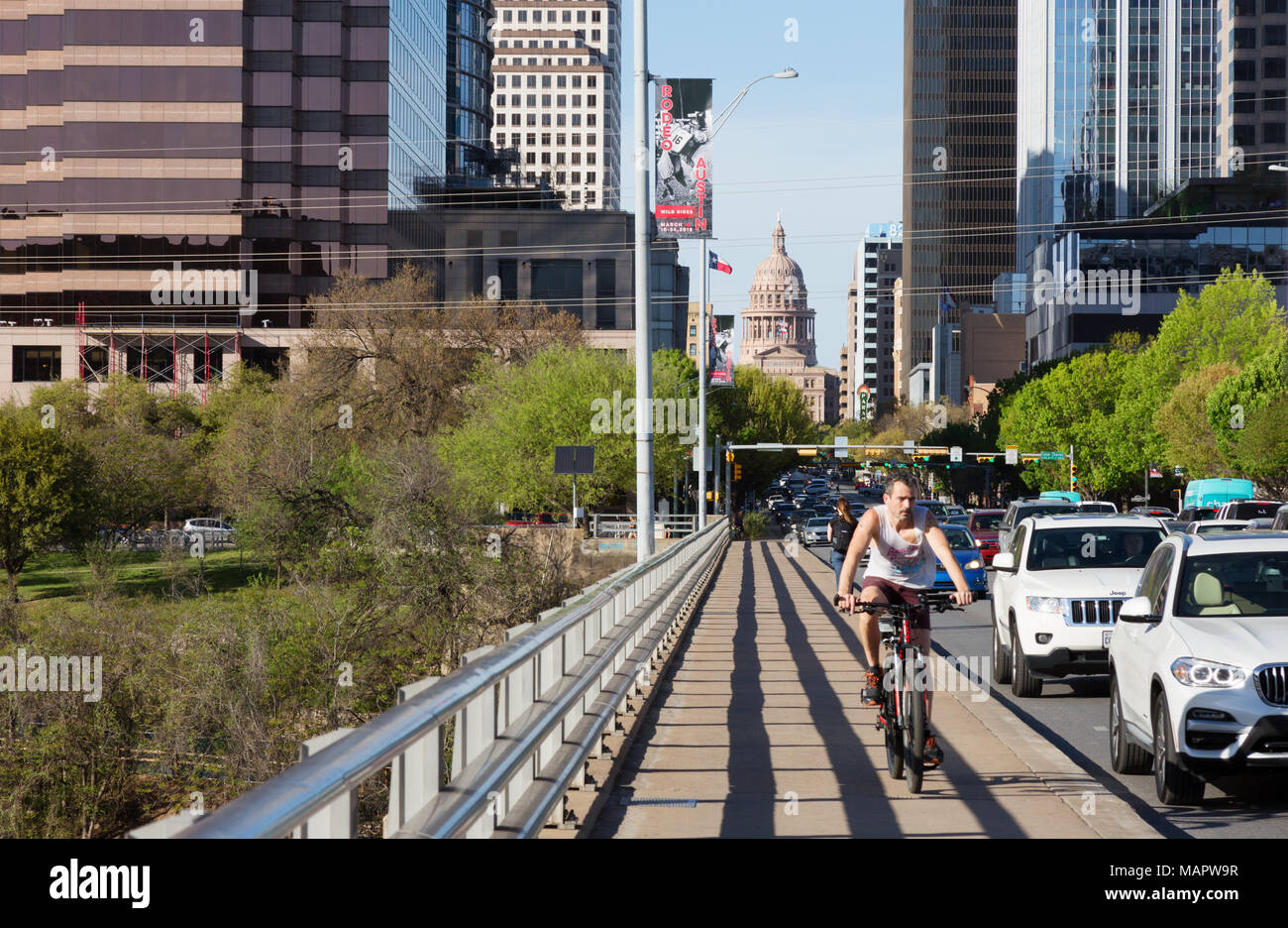 Un homme à vélo, Congress Avenue Bridge, le centre-ville d'Austin, Austin, Texas USA Banque D'Images