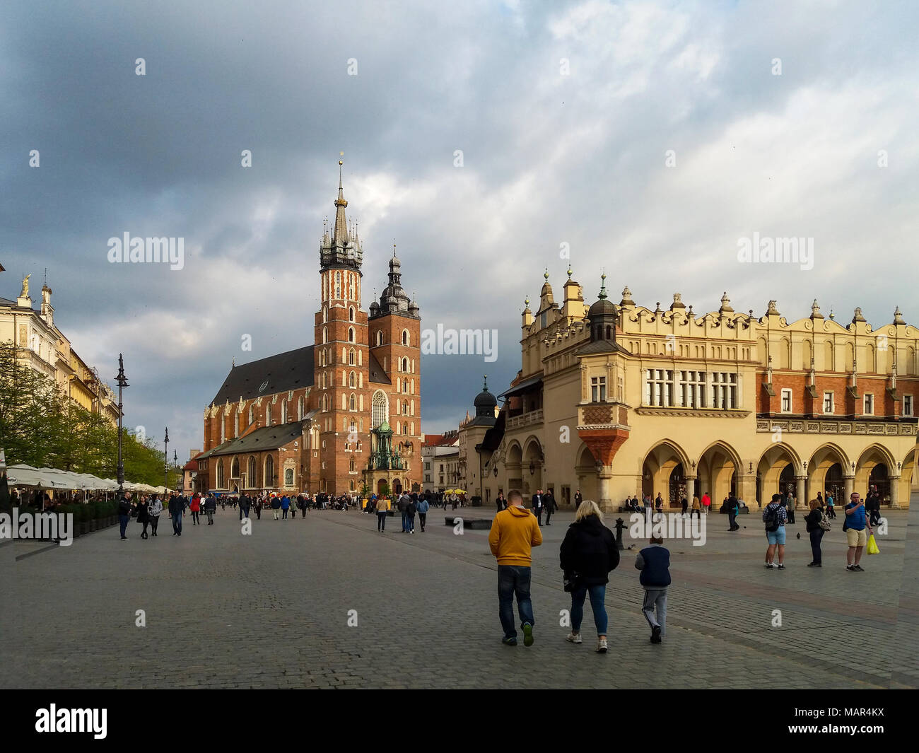 Cracovie, Pologne - 7 mai 2017 : Place du marché (Rynek), l'église gothique St Mary Mariacki), (ancienne salle des tabliers (Sukiennice) et la marche à pied. Météo Banque D'Images