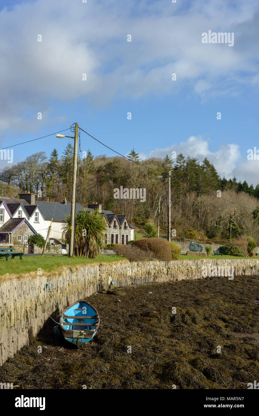 Bateau de pêche bleu par jetée en pierre à marée basse dans le port de Kenmare, comté de Kerry, Irlande. Banque D'Images