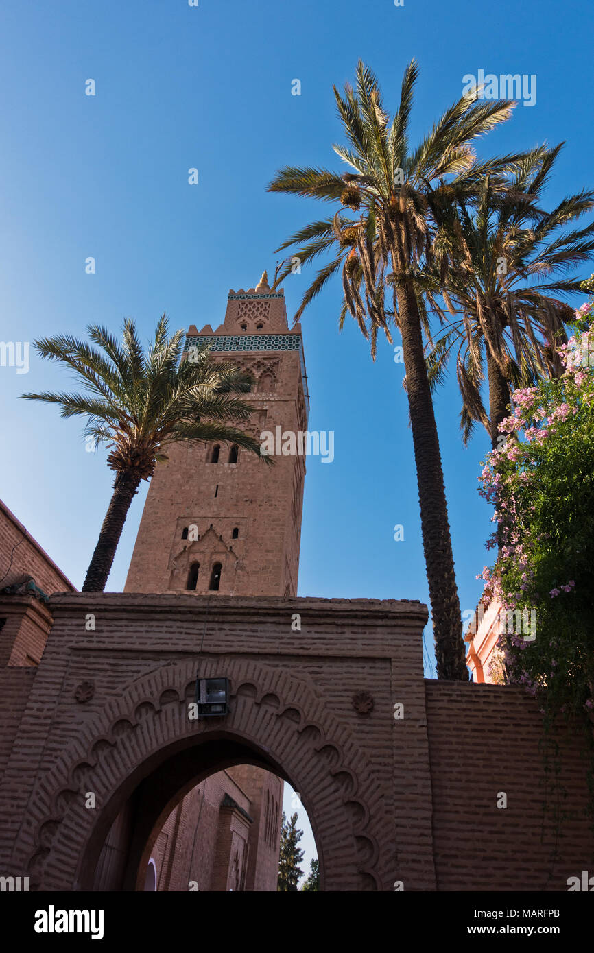 Vintage gate avec des palmiers en face de la Koutoubia au coucher du soleil, Marrakech, Maroc Banque D'Images