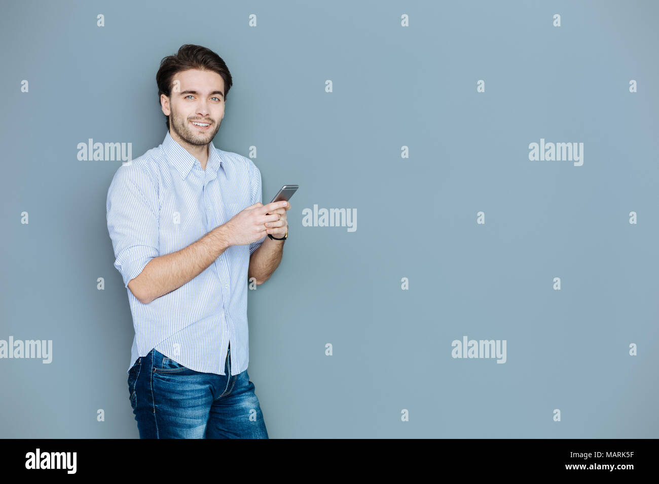 Heureux homme séropositif en utilisant son smartphone Banque D'Images