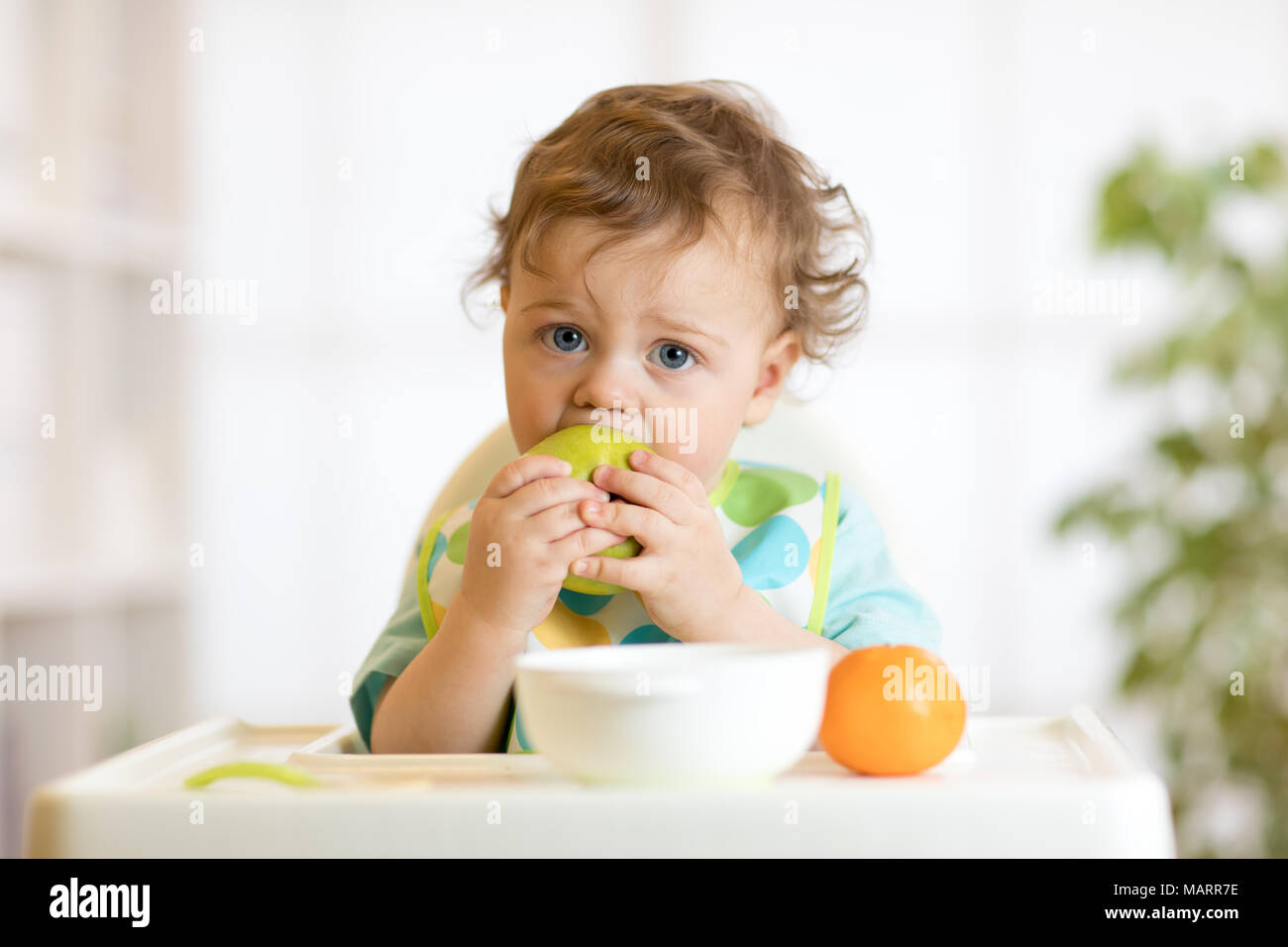 Mignon Bebe 1 Ans Assis Sur Une Chaise D Enfant Et Manger Des Fruits Seuls Dans Cuisine Blanche Photo Stock Alamy Mignon Bebe 1 Ans Assis Sur Une Chaise D Enfant Et Manger Des Fruits Seuls Dans Cuisine Blanche Photo Stock Alamy