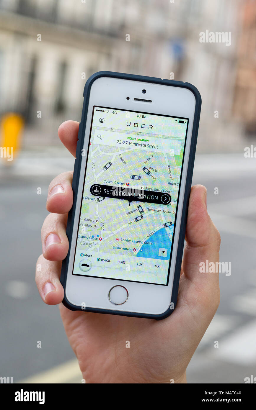 Tenir la main à l'aide d'Apple iPhone app Uber, London, UK Banque D'Images