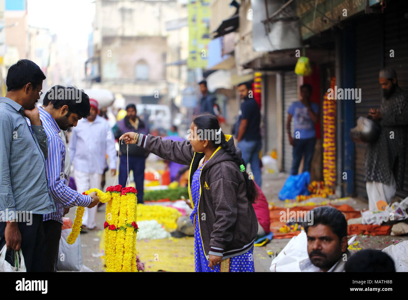 Bangalore, Inde - le 23 octobre 2016 : Inconnu les gens d'acheter des guirlandes de fleurs d'un vendeur au bord de la KR marché. Banque D'Images