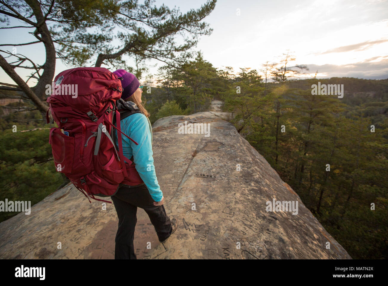 Un female hiker explorer Sky Bridge dans la Red River Gorge de KY au lever du soleil. Banque D'Images