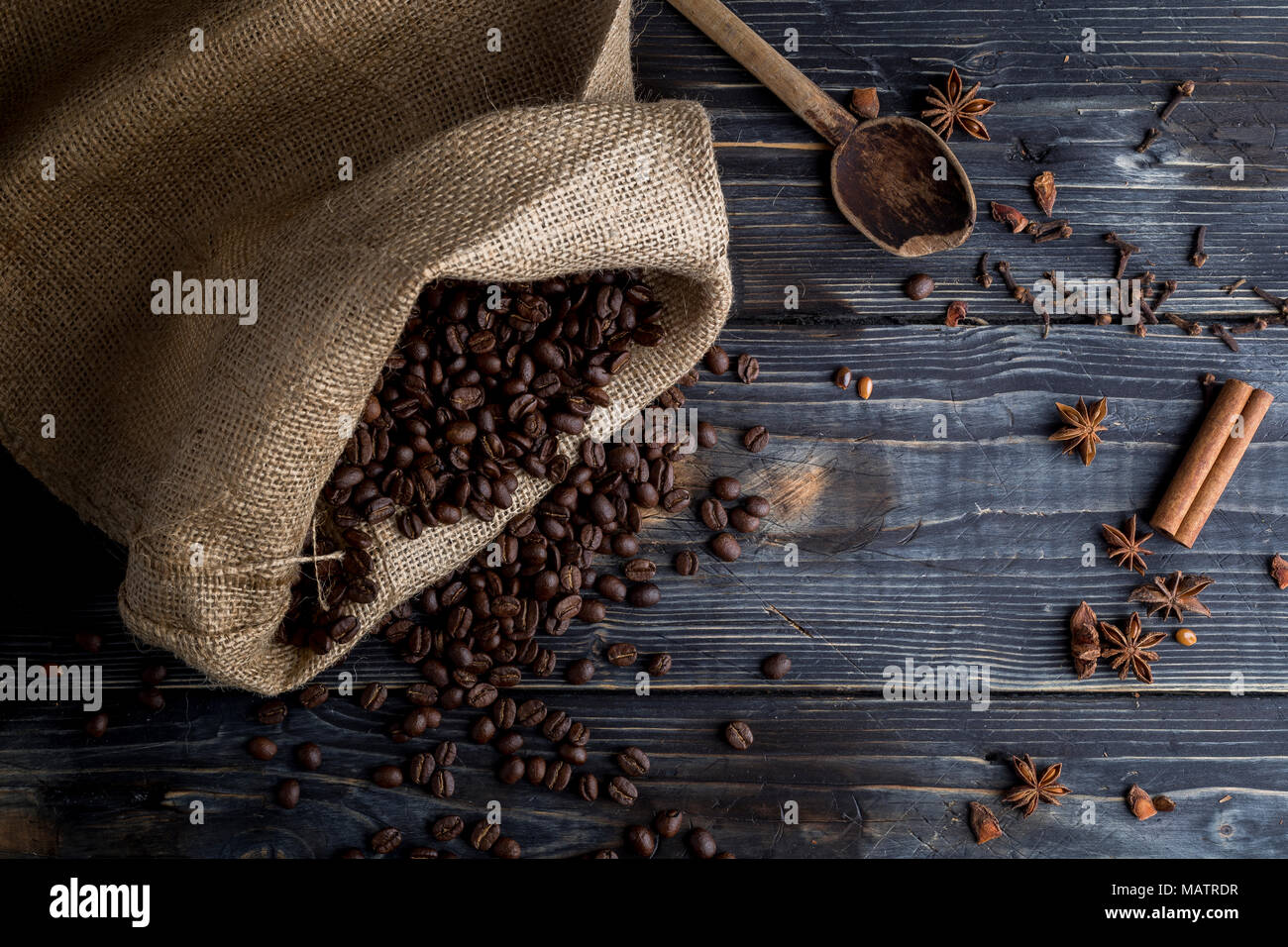 Les grains de café sur le fond de bois, sac de jute et épices Banque D'Images