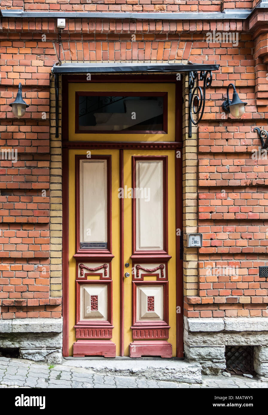 Porte en bois rouge avec le verre dans un bâtiment en briques rouges en Europe. Thème architectural Banque D'Images