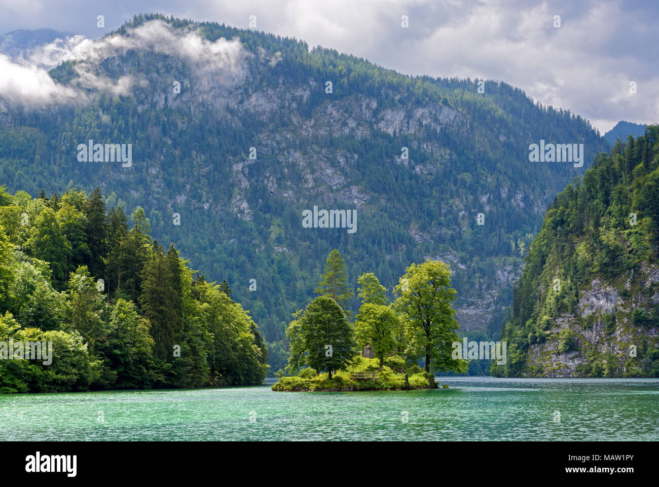 Petite île boisée contre rock et de nuages sur le lac Königssee, Allemagne Banque D'Images