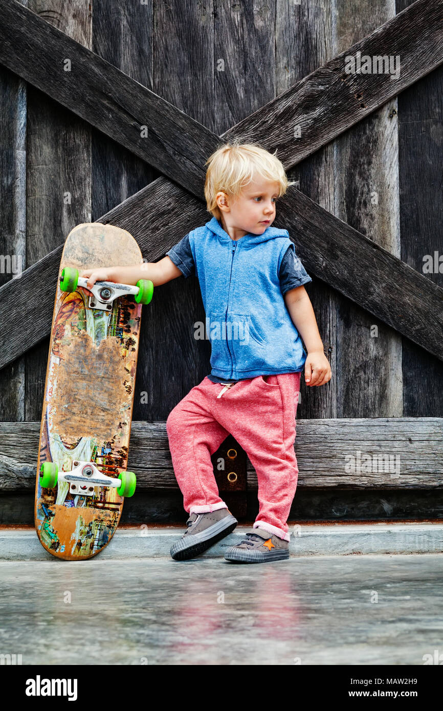 Peu de patineur avec skateboard s'amuser avant que les enfants en classe Formation skate parc actif famille mode de vie, activités de loisirs en plein air à l'été Banque D'Images