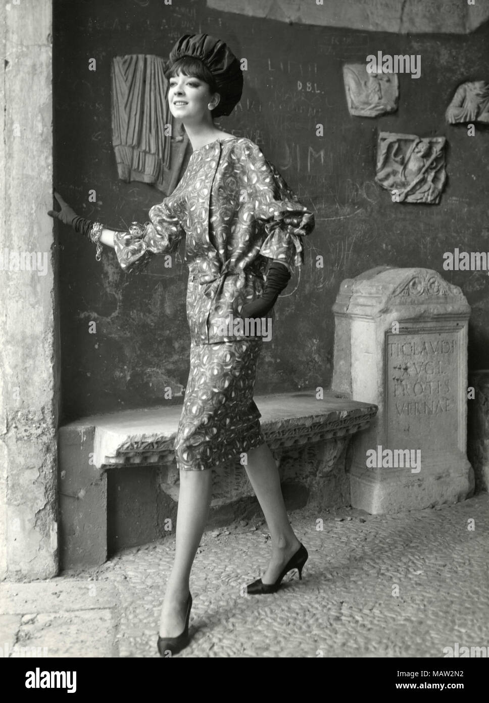 Modèle des années 60 portant un chapeau, gants longs, et robe à motifs, Italie Banque D'Images