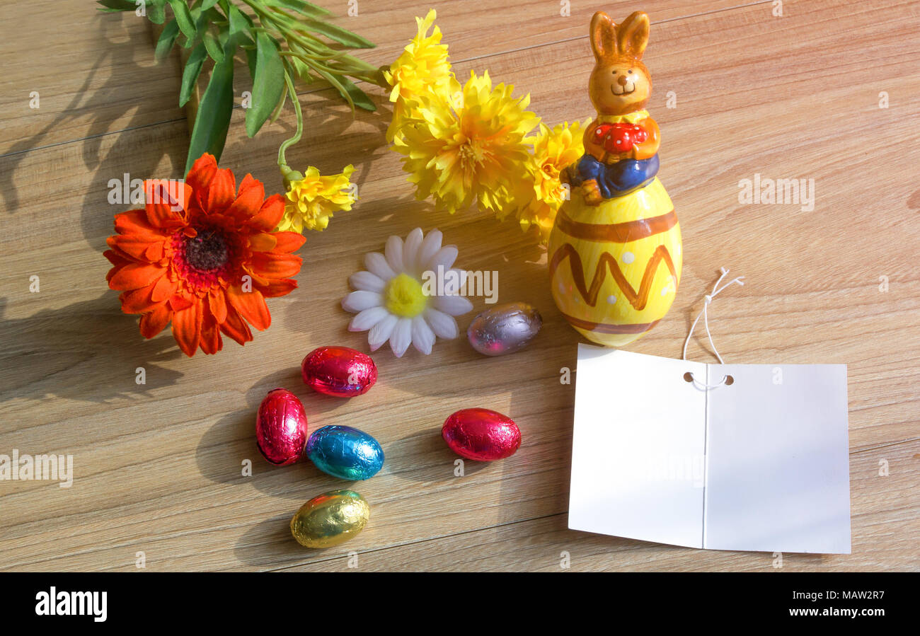 Concept de Pâques. Joyeuses Pâques journée avec des œufs, carte de vœux, fleurs et céramique lapin sur table en bois avec l'exemplaire de l'espace. Banque D'Images Concept de Pâques. Joyeuses Pâques journée avec des œufs, carte de vœux, fleurs et céramique lapin sur table en bois avec l'exemplaire de l'espace. Banque D'Images